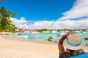 Femme au chapeau sur plage de Grand-Baie, île Maurice 