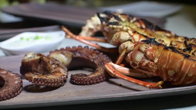 Caribbean spiny lobsters cooking at grill . .