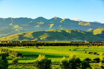 Nalati grassland with beautiful mountain natural landscape in Xinjiang at sunset,China.