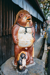 Japanese raccoon dog Tanuki ceramic Mascot at Japan shop front Traditional folklore
