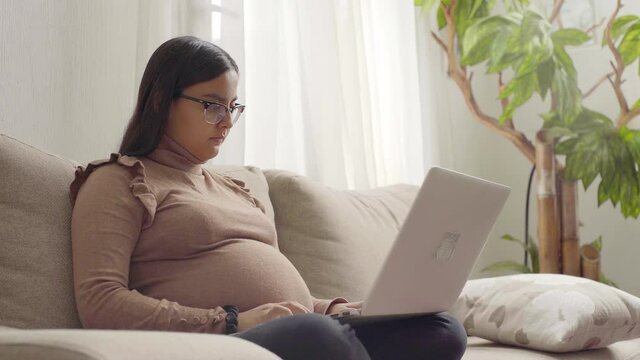 4k A Young Pregnant Latinx Woman Working On Laptop