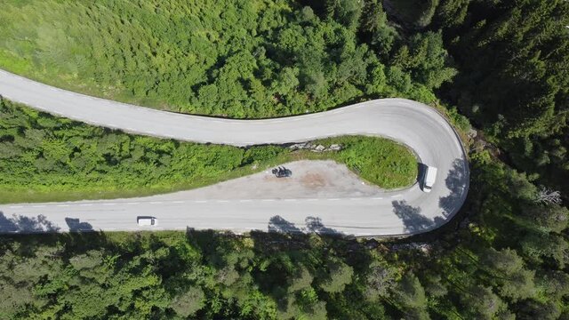 180 degree curve at winding road E39 through deep forest in F&oslash;rde Norway - Static top down birdseye aerial view with passing cars