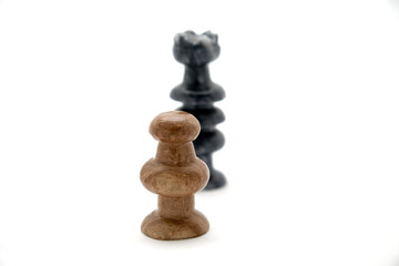Chess pieces, white pawn and black queen face off