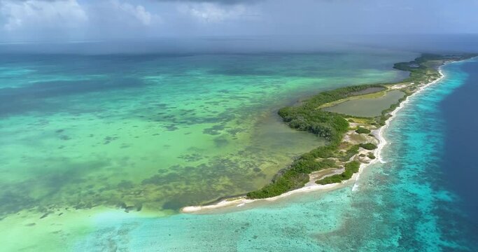Moving-turn pan LEFT  aerial view bocade  Cote island and nube verde Caribbean sea Los roques Venezuela  with blue water and Green mangrove.