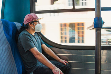 Young latin man sitting in the bus. Man relaxed in the bus transport on a sunny day