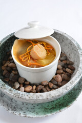 double boiled shark's fin scallop seafood cordycep flower soup in hot stone pot in white background asian halal menu