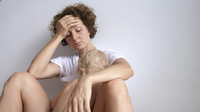 Young sleep deprived mother trying to coup with exhaustion while breastfeeding her child. Postpartum fatigue. 