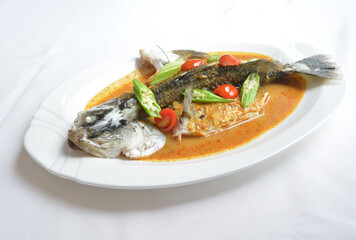 local peranakan curry sauce with grouper fish seafood with vegetables in white background asian halal menu