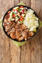 Hawaiian Style Slow Cooker Kalua Pork served with stewed cabbage and fresh salad closeup in the slate plate on the table. Vertical top view from above