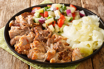 Kalua pork hawaiian food slowly cooked and served with stewed cabbage and fresh salad close-up in a...