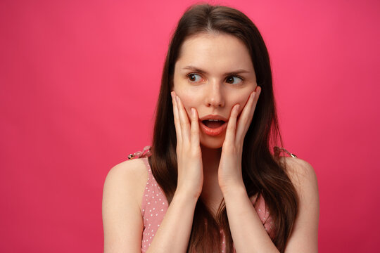 Shocked and surprised girl screaming against pink background