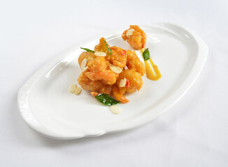wok fried seafood prawn in pumpkin salted egg yolk sauce in white background asian halal menu