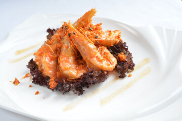 deep fried crispy big fresh tiger prawn in spicy chilli curry sauce in hot clay pot in white background asian halal menu