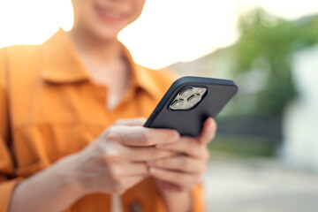 Woman uses mobile phone and Internet technology in park outdoor.
