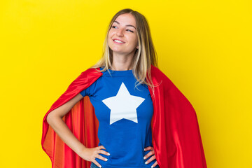 Super Hero Romanian woman isolated on yellow background posing with arms at hip and smiling