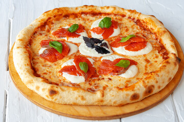Hot pizza Margherita on white wooden table