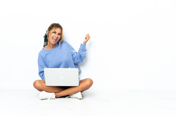 Fototapeta premium Young blonde Uruguayan girl with the laptop isolated on white background making guitar gesture
