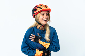 Young blonde Uruguayan cyclist woman isolated on background smiling a lot