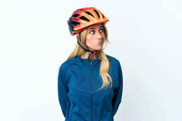 Young blonde Uruguayan cyclist woman isolated on background and looking up