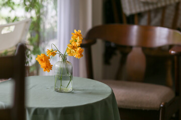 selective focus glass vase with yellow flowers. shop decoration concept Use materials near the body of the leftovers, old bottles. There is space for text.