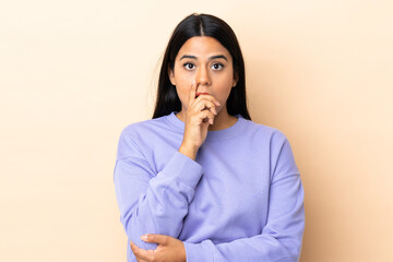 Young latin woman woman over isolated background surprised and shocked while looking right