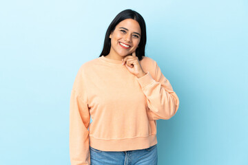 Young latin woman woman isolated on blue background laughing