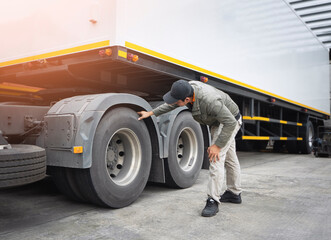 Asian A Truck Driver is Checking Trailer Truck Wheels and Tires. Inspection Maintenance and Safety...