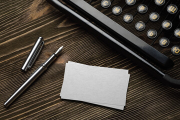 Stack of blank white business cards with typewriter and fountain pen. Mock-up template.