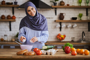 Beautiful Arabian housewife cooking a meal in her kitchen
