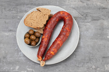 typical portuguese smoked sausage chourico with olives and bread