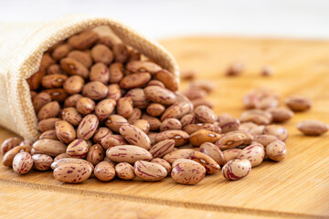 Raw Organic cranberry bean on wooden background.