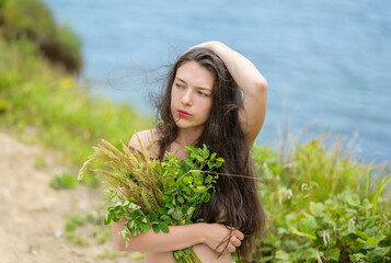 Young woman with summer grass. Outdoor portrait.