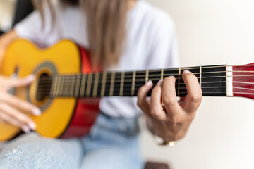 Detailed picture of a female's hand practising different chords on a guitar