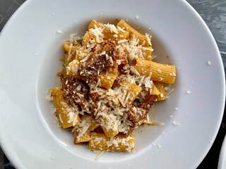 Rigatoni Pasta Alla Genovese, a typical Neapolitan Recipe with Parmesan Cheese, Onions and Meat in an Italian Restaurant.