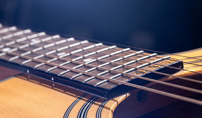 Close-up of a guitar fretboard on a black background.