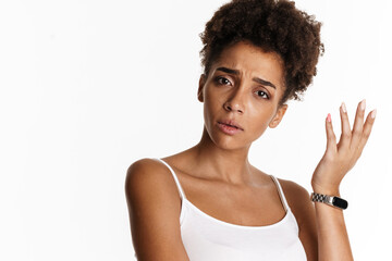 Fototapeta na wymiar Young black woman in tank top frowning and gesturing at camera