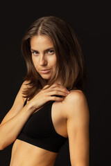 Fototapeta premium Close-up portrait of young beautiful tanned pretty woman without makeup isolated over black studio background. Natural beauty, facial emotion concept.