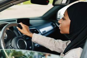 Fototapeta na wymiar Black muslim woman looking forward while driving car