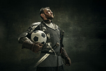 Portrait of one brutal bearded man, medeival warrior or knight with ball over dark background.