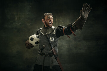 Portrait of one brutal bearded man, medeival warrior or knight with ball over dark background.