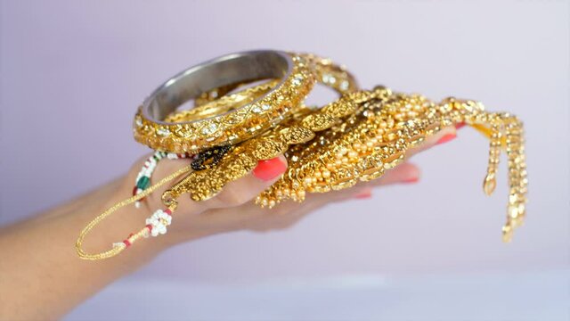 Indian woman holding beautiful gold jewelry - fashion and style. Gold loan against jewelry and gold. Personal saving  Pure gold jewelry 