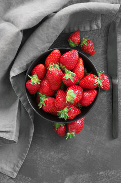Fresh strawberries in bowl on grey