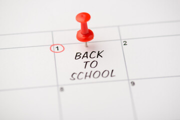 Closeup photo of mark on calendar at first inscription back to school with red pushpin