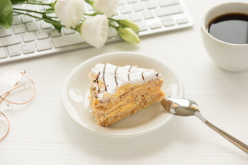 Photo of piece of cake on saucer dessert spoon spectacles white cup of coffee and flowers on white...