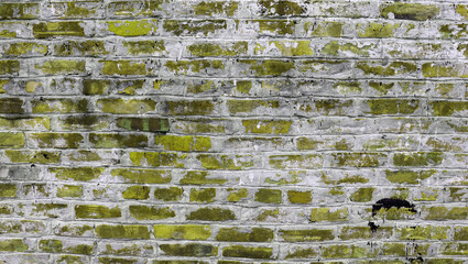 Old yellow brick wall with cracks of rural building