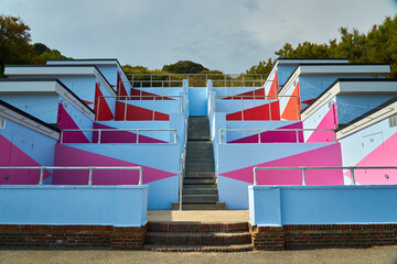 Blue and pink abstract concrete building with trees in the background