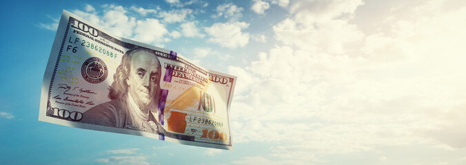 Money 100$ dollar bill flying on sky
