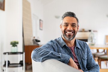 Happy mature indian man smiling at home