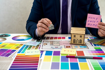 Designer develops a sketch of interior illustration with color scheme of material on a table, office workplace.  Desktop of an architect and interior designer with samples