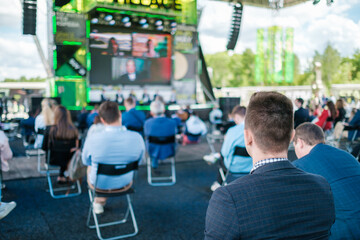 Participants of open air conference listening to speaker